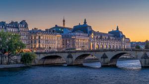 a bridge over a river in front of buildings at 2063 - Orsay studio in Paris Olympic Games 2024 in Paris