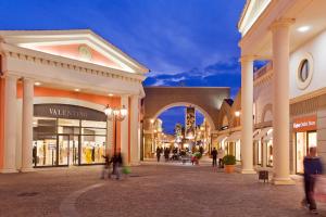 Un gruppo di persone che camminano per un centro commerciale di Bed and Breakfast Roma a Mostacciano