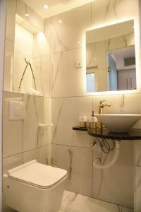une salle de bain blanche avec toilettes et lavabo dans l'établissement Syntagma square, 30sqm Nikis luxurious Studio, à Athènes