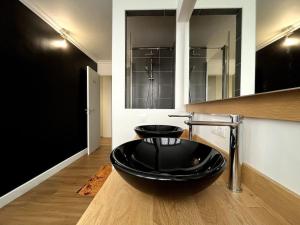 een badkamer met een zwarte wastafel op de vloer bij Familial Apartment - Troyes in Troyes
