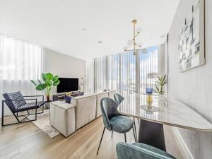 a living room with a glass table and chairs at Pass the Keys Modern 2-BR Penthouse Oasis Ideal for Business Family and Group Retreats in Trendy Fulham in London