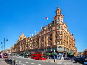 a large building with a red bus in front of it at Pass the Keys Modern 2-BR Penthouse Oasis Ideal for Business Family and Group Retreats in Trendy Fulham in London