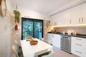 een keuken met een witte tafel en een tafel en stoelen bij Apartamento Beira Mar - 1º Direito in Tavira