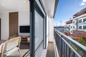 een balkon met een televisie en een bureau in een gebouw bij Apartamento Beira Mar - 1º Direito in Tavira