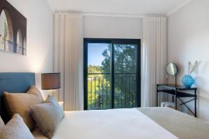 een slaapkamer met een bed en uitzicht op een balkon bij Apartamento Beira Mar - 1º Direito in Tavira