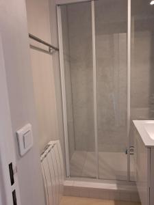 um chuveiro com uma porta de vidro na casa de banho em Le Sylvania em Saint-Georges-de-Didonne