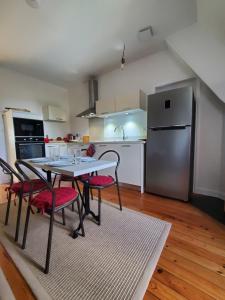 a kitchen with a table and chairs and a refrigerator at Logis des Tourelles Appartement in Cognac