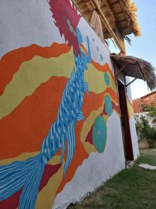 ein Pfauenmal an der Seite eines Gebäudes in der Unterkunft Casa Flora Canoa Quebrada in Canoa Quebrada