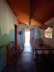 uma sala de jantar com mesas e cadeiras e uma porta em Casa Flora Canoa Quebrada em Canoa Quebrada