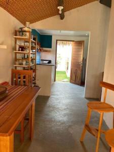 a kitchen with a wooden table and chairs and a door at Casa Flora Canoa Quebrada in Canoa Quebrada +44 photos