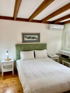 a bedroom with a large white bed and two tables at Erietta Suites in Chania