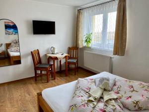 1 dormitorio con 1 cama, mesa y sillas en Villa Slnecnica, en Nová Lesná