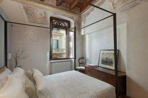 a bedroom with a canopy bed and a window at Residenza Roccamaggiore in Verona