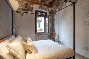 维罗纳罗佳玛姬儿公寓的带天蓬床和窗户的卧室