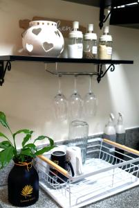 uma prateleira numa cozinha com óculos e uma planta em Serenity Condo: Your Cozy Place At Stanford Suites 2 w/ Private Parking em Silang