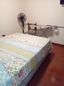 a bed with a quilt on it with a fan at Baquedano in Antofagasta