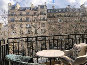 a balcony with chairs and a table and a building at Grand appartement proche métro in Paris