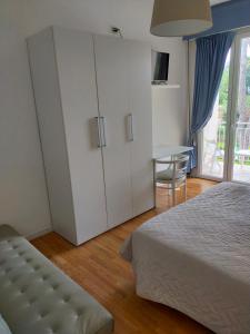a bedroom with a large white cabinet and a table at MILANO in Marina di Pietrasanta