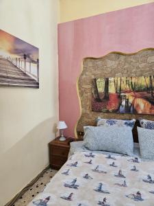 sypialnia z łóżkiem i obrazem na ścianie w obiekcie casa porta nuova w mieście Palermo