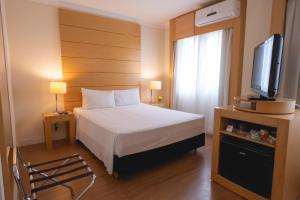 a hotel room with a bed and a television at eSu&iacute;tes Congonhas by Atlantica in Sao Paulo