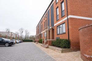 a brick building with cars parked in a parking lot at Luxury Worcester Townhouse - Free Parking in Henwick