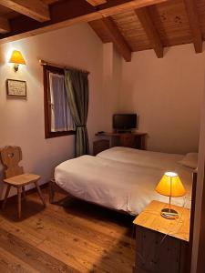 a bedroom with a bed and a table with a lamp at Agriturismo Busa dei Sbrase 