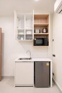 a kitchen with a sink and a microwave at Townhouse in Pratunam Bangkok in Bangkok