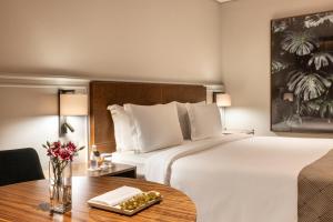 a hotel room with a large bed and a table at L'Hotel PortoBay São Paulo in Sao Paulo