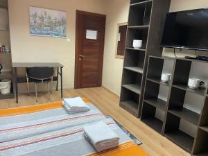 a living room with a flat screen tv and shelves at Coral guest house Netanya in Netanya