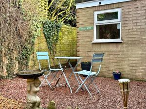 a table and two chairs and a table and a window at Firs Nook with Parking in Stillington