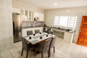 a kitchen with a table and chairs and a refrigerator at Respiro na Serra, casa no coração de Gonçalves in Gonçalves