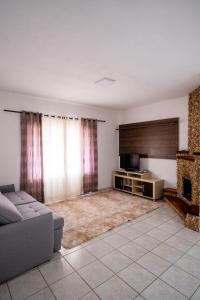 a living room with a couch and a fireplace at Respiro na Serra, casa no coração de Gonçalves in Gonçalves