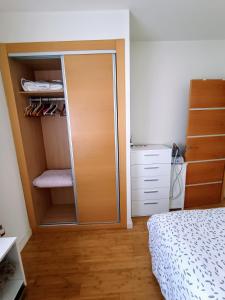 a bedroom with a closet with a door and a bed at Acogedora habitación privada en Villa Mayka in Granada