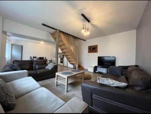 ein Wohnzimmer mit einem Sofa und einem Tisch in der Unterkunft Maison 10 couchages secteur Fontainebleau in Vernou-sur-Seine