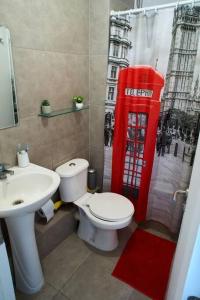 a bathroom with a toilet and a sink and a red phone booth at Departamento amoblado en arriendo in Arica