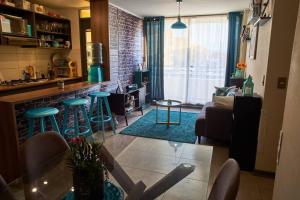 a living room with a bar and some stools at Departamento amoblado en arriendo in Arica