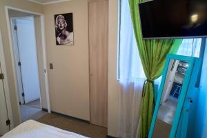 a room with a television and a window with a curtain at Departamento amoblado en arriendo in Arica