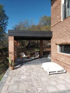 un patio con un edificio in mattoni con tetto nero di Casa para disfrutar! ad Agua de Oro
