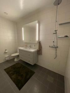 a white bathroom with a sink and a mirror at Orrvägen in Torshälla