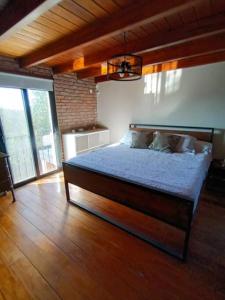 una camera con un letto in una stanza con pavimenti in legno di Casa para disfrutar! ad Agua de Oro