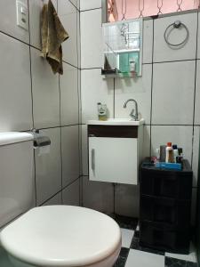 ein Badezimmer mit einer weißen Toilette und einem Waschbecken in der Unterkunft Alojamento do João in Lagoa Santa + 4 Fotos