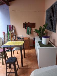 ein Wohnzimmer mit einem Tisch, einem Tisch und Stühlen in der Unterkunft Alojamento do João in Lagoa Santa