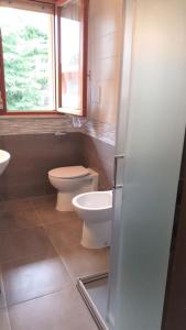 ein Bad mit einem WC und einem Waschbecken in der Unterkunft Holiday by the pool in our cozy flat - Beahost in Bibione