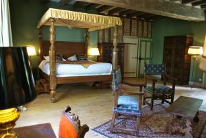 a bedroom with a canopy bed and chairs at Manoir de la Touche in Azay-le-Rideau