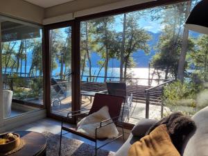 sala de estar con vistas al agua en Departamento con vista al lago y piscina climatizada en Villa La Angostura