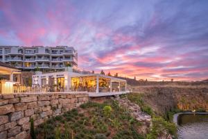 a large white building with a sunset in the background at Hacienda el Sueno in Fuengirola