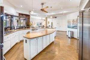 a large kitchen with white cabinets and a large island at Sundance in the Foothills in Tucson