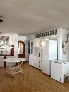uma cozinha com uma mesa e um frigorífico branco em 3aguas Mediterraneo y Piscina em La Manga del Mar Menor