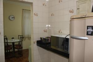 una pequeña cocina con microondas y mesa en Anfitrioca Apartamento Gloria, en Río de Janeiro