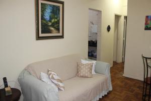 a living room with a couch with pillows on it at Anfitrioca Apartamento Gloria in Rio de Janeiro